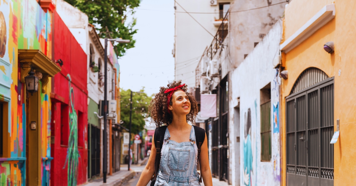 A picture of a woman strolling through a colorful street.